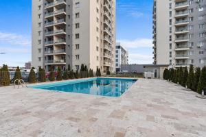 a swimming pool in front of two tall buildings at Studio in Dimri Residence in Bucharest