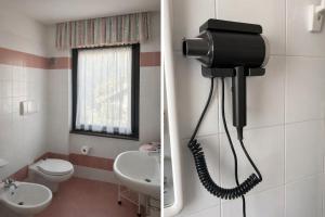 a bathroom with a phone hanging on the wall at Chalet La Felce in Carisolo +21 photos
