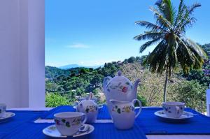 un tavolo blu con tazze e set per la preparazione del tè sopra di Kandyan White Holiday Homes a Kandy