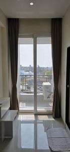 a room with a large glass door with a balcony at Emerald Nest in Pandharpur
