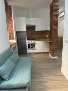 a living room with a blue couch in a kitchen at La Casa de Mara in Madrid
