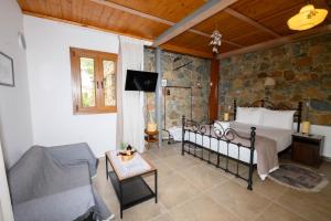 a bedroom with a bed and a tv in a room at Fikardou Chalets in Phikardhou +67 photos