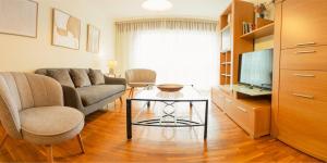 a living room with a couch and a table and a tv at Ravella Vilagarcía de Arousa in Vilagarcia de Arousa