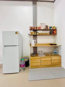 a kitchen with a white refrigerator and a wooden shelf at Comfort Home stay Private Room A Shared House in Ban Tha Khun