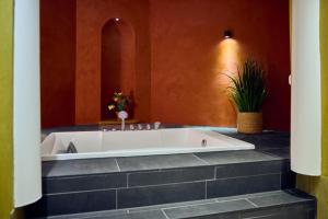 a large bath tub in a bathroom with at Hotel Duinrand Drunen in Drunen +10 photos