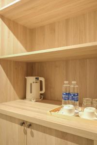 a shelf with bottles of water and a coffee maker at Lens Stay in Ho Chi Minh City +78 photos