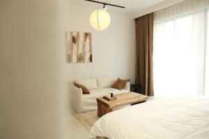 a bedroom with a bed and a couch and a table at Lens Stay in Ho Chi Minh City