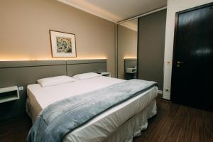 a bedroom with a large white bed in a room at Eco Stay in Curitiba +3 photos