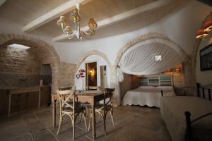 a bedroom with a table and chairs and a bed at Tipico Resort in Alberobello