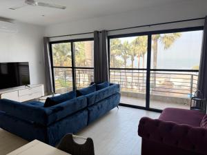 a living room with a blue couch and a view of the ocean at Relax Ocean Views in Bijilo