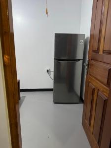 a kitchen with a stainless steel refrigerator in a room at Dilco Villa Ahangama in Ahangama