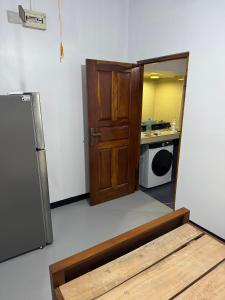a kitchen with a wooden door and a refrigerator at Dilco Villa Ahangama in Ahangama