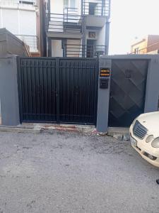 a gate with a car parked in front of a building at AS MONTENEGRO SUITES in Podgorica