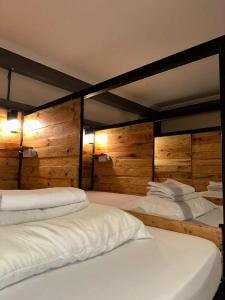 a room with three beds with wooden walls at Yellow Umbrella Hostels in Cebu City