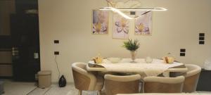 a dining room with a table with chairs and paintings at شارع الاربعين حديقه بدر in Cairo