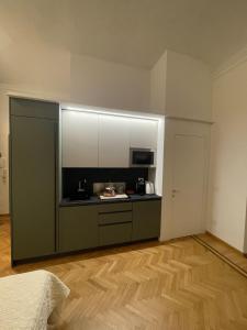 a kitchen with white cabinets and a wooden floor at Casa Ferrara in Novara