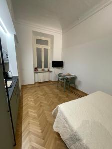 a bedroom with a bed and a table and a television at Casa Ferrara in Novara