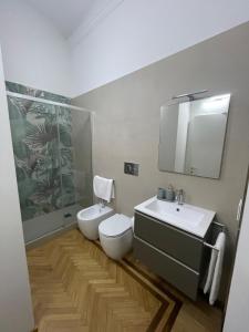 a bathroom with a toilet and a sink and a mirror at Casa Ferrara in Novara +14 photos