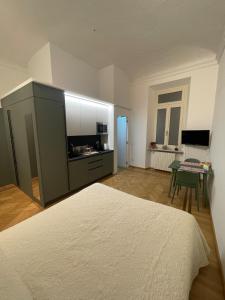 a bedroom with a bed and a kitchen with a table at Casa Ferrara in Novara