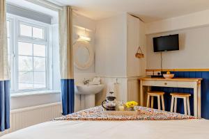 a bedroom with a bed and a sink and a table at 1605 by the sea in Falmouth
