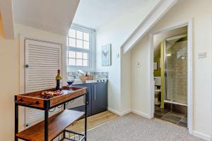 a kitchen with a table with a bottle of wine at 1605 by the sea in Falmouth