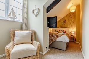 a bedroom with a bed and a chair in a room at 1605 by the sea in Falmouth