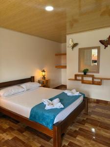 a bedroom with a bed with two towels on it at Hotel y Club Pueblito Quindiano Montenegro in Montenegro +100 photos