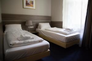 two beds in a hotel room with a window at City Hotel - HEEFA OHG in Hamburg