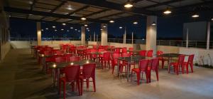 a group of tables and chairs on a balcony at night at Emerald Nest in Pandharpur