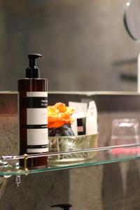 a bottle of mouth wash sitting on a glass shelf at Hotel Garni Villa Arrisja in Eefde +56 photos
