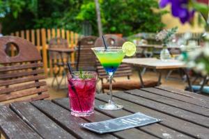 two cocktails sitting on a wooden table on an outdoor table at Pension Burgenring in Schlitz +21 photos