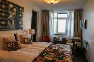 a hotel room with a bed and a window at Hotel Garni Villa Arrisja in Eefde