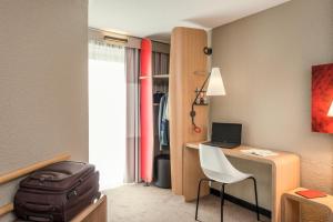 
a room with a bed, chair and a desk at Ibis Paris Gare Montparnasse 15ème in Paris

