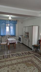 a living room with a table and a kitchen at Krat in Osh
