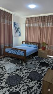 a bedroom with a bed with blue sheets and curtains at Krat in Osh