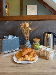 a table topped with a plate of croissants and coffee at LE CHAMPENOIS-Appartement central près de l' Avenue de Champagne in Épernay