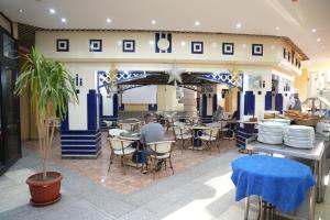 a man sitting at a table in a restaurant at Gaddis Hotel, Suites and Apartments in Luxor