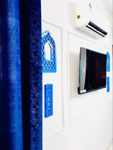 a room with blue curtains and a tv on a wall at Vogue- Lavish collection in Zirakpur