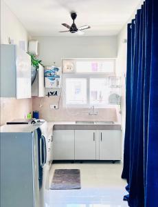 a kitchen with a sink and a ceiling fan at Vogue- Lavish collection in Zirakpur
