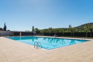 a large swimming pool with blue water in a building at Camping Ridaura in Llagostera