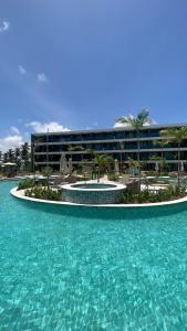 a resort with a pool of water in front of a building at Flats Beach Class Verano - Muro Alto, Porto de Galinhas in Ipojuca