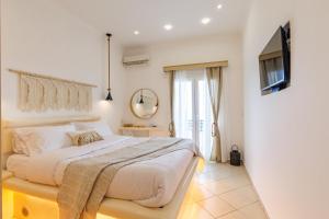 a bedroom with a large bed and a mirror at Golden Secret Beach House in Perissa