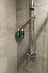 a shower with two soap bottles on the wall at Bellu Suites by GuestPro in Guimarães +71 photos