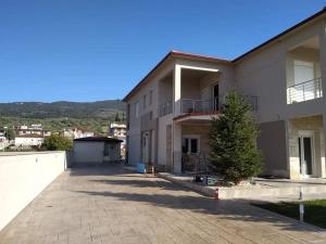 a large white house with a tree in front of it at Studio Giannis, a breath away from Athens! in Neméa