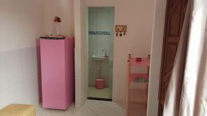 a bathroom with a pink refrigerator and a sink at Casa Rosa da Ilha - Suíte Confortável com Ventilador e Jardim in Vera Cruz de Itaparica