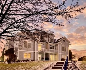 a large white house with a tree at Serenity on the Shores in Portage