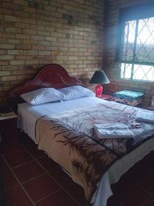 a bedroom with a large bed with a brick wall at Casa Oliva in Sáchica