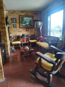 a living room filled with furniture and a brick wall at Casa Oliva in Sáchica
