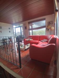 a living room with a red couch and a table at Casa Oliva in Sáchica +8 photos