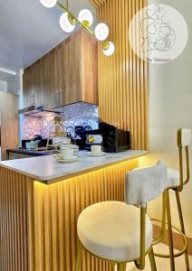a kitchen with a counter with a chair and a microwave at The Turianos in Manila